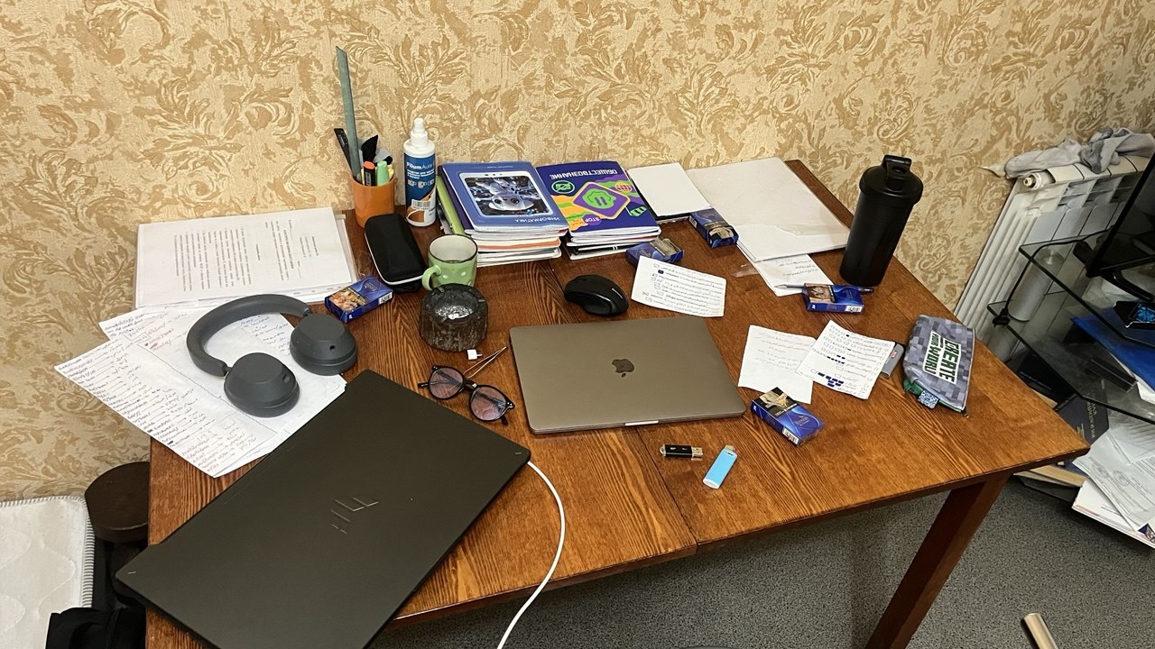 The first desk — everything piled on one old table